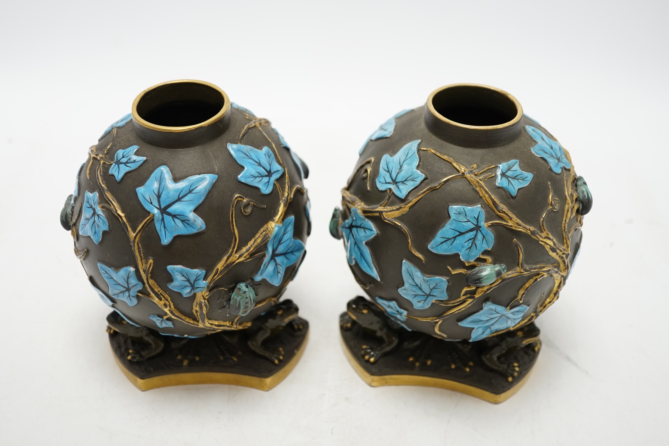 A pair of George Jones Kumassie vases designed by Christopher Dresser, relief moulded designs, frog supports, 14cm. Condition - good